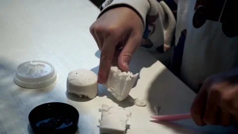 Child cutting play dough in halves Stock Footage 219107904