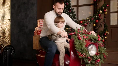 Child with dad In the New Year's interior are sitting on a moped on the Stock Footage 167307488