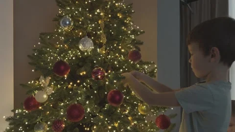 Child Decorating Christmas Tree Hanging Red Ornament Close Up Festive Holiday Stock Footage 344882312