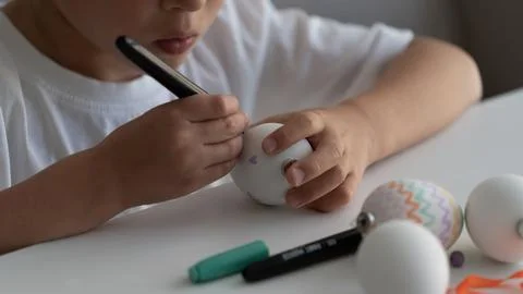 Child Decorating Easter Egg with Marker Close Up Photos