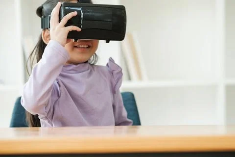 Child Delighted by Virtual Reality Experience An elementary aged girl uses... Fotos de archivo