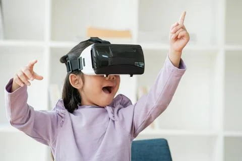 Child Delighted by Virtual Reality Experience An elementary aged girl uses... Fotos de archivo
