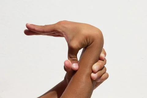 Child demonstrating thumb flexibility by bending it toward his arm Stock Photos
