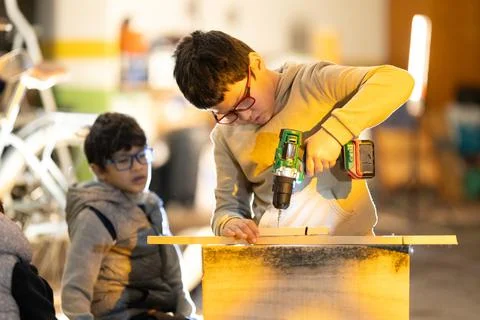 Child developing practical skills using power drill Foto stock