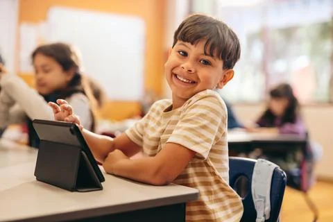 Child development in action as young kid learns to code with a tablet in scho Stock Photos
