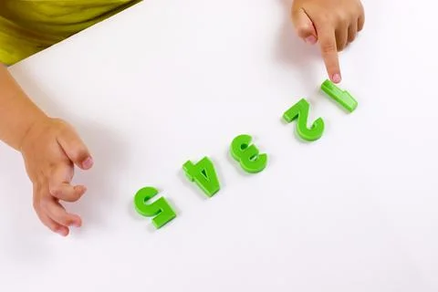 Child development. Counting training. The child points to the numbers. selective Stock Photos
