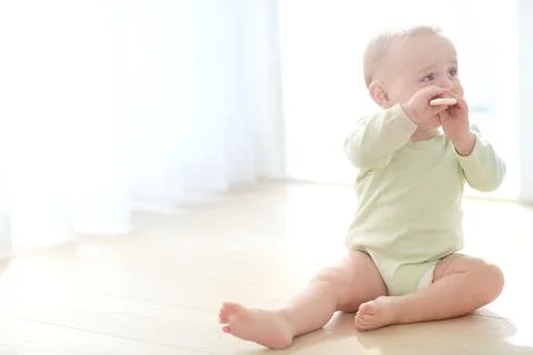 Child development, milestone and teething biscuit with toddler on floor in .. Stock Photos