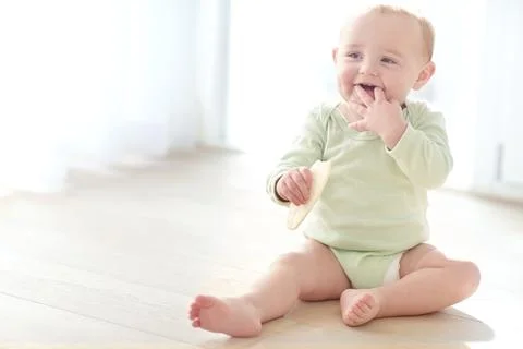 Child development, smile and teething biscuit with toddler on floor in livi.. Stock Photos
