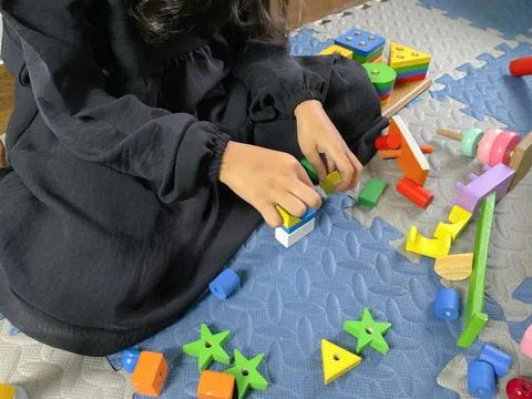 Child with Developmental Delay Engaging in Occupational Therapy with Wooden Stock Photos