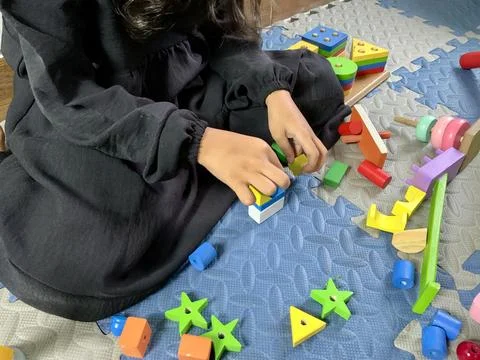 Child with Developmental Delay Engaging in Occupational Therapy with Wooden Stock Photos