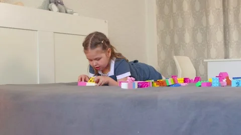 A child develops creativity while stacking blocks on the carpet 動画素材 312738472