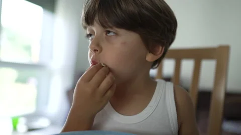 Child devouring broccoli super food. Portrait of kid eating vegetable sitti.. Stock Footage 236953720