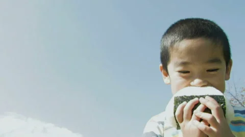Child Devouring Rice Balls Video stock 332756612