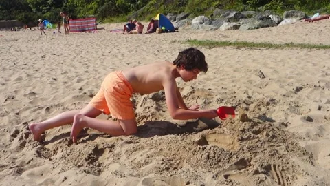 Child digging a hole on a beach Stock Footage 161013652