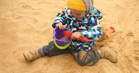 Child is digging the sand coldly Stock Footage 90301905