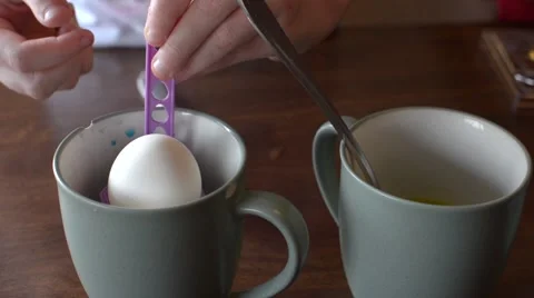 A child dipping an Easter egg into the blue dye Stock Footage 60267176
