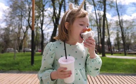Child with a dirty face eats sweets outdoors Stock Footage 193768200