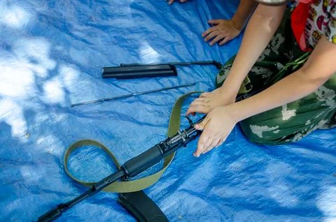 Child disassembling rifle Foto stock
