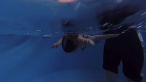 The child dives under the water in the pool 스톡 동영상 85302945