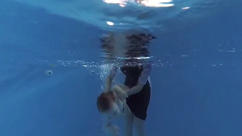 The child dives under the water in the pool Vídeo Stock 85302965