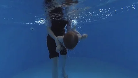 The child dives under the water in the pool Видео 85302973