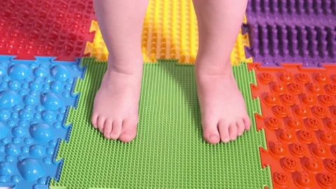The child does exercises on the orthopedic mat, legs close-up. Stock Footage 169637726