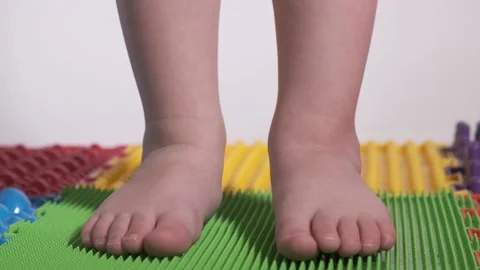 The child does exercises on the orthopedic mat, legs close-up. Stock Footage 169950994