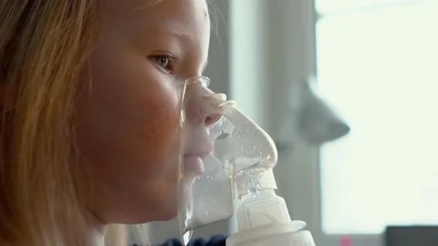 The child does the inhalation procedure with a nebulizer of the respiratory trac Stock Footage 147979422