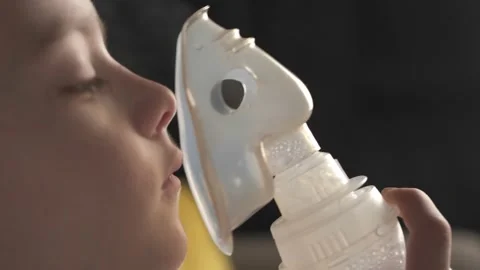 The child does the lung inhalation procedure at home. Inhalation when coughing.  Stock Footage 165826321