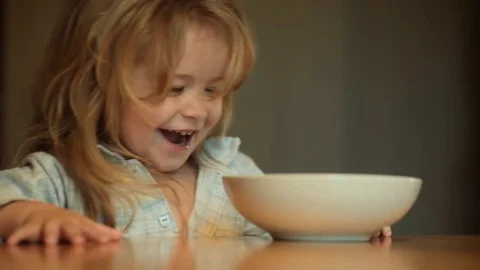 Child does not want to eat, cute child with long hair in pajamas in kitchen Stock Footage 79617684