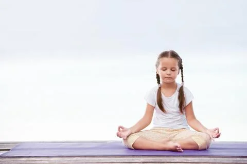 Child doing exercise on platform outdoors. Healthy lifestyle. Yoga girl Foto stock