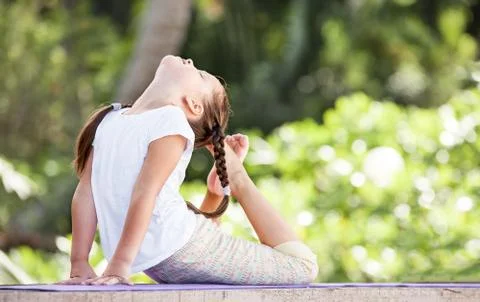 Child doing exercise on platform outdoors. Healthy lifestyle. Yoga girl Stock Photos