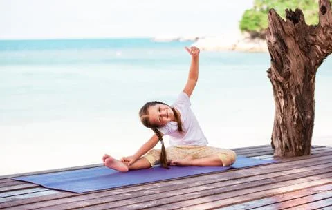 Child doing exercise on platform outdoors. Healthy lifestyle. Yoga girl Foto stock