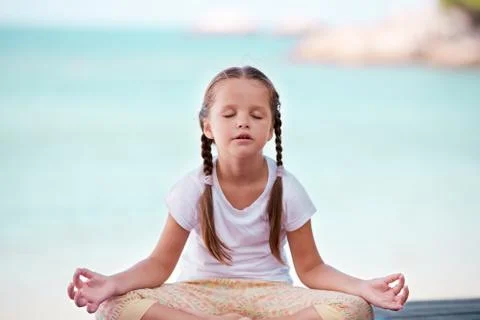 Child doing exercise on platform outdoors. Healthy lifestyle. Yoga girl Stock Photos