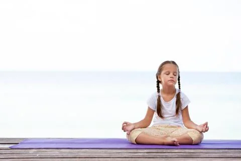 Child doing exercise on platform outdoors. Healthy lifestyle. Yoga girl Foto stock