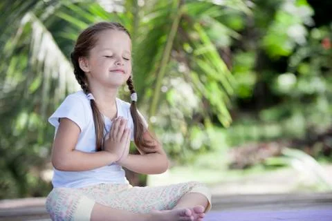 Child doing exercise on platform outdoors. Healthy lifestyle. Yoga girl Foto stock