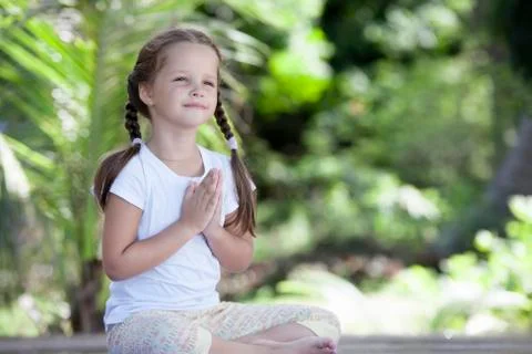 Child doing exercise on platform outdoors. Healthy lifestyle. Yoga girl Stock-Fotos