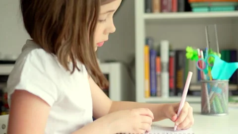 Child doing her homework at the dest at home. Education concept. Stock Footage 301976503