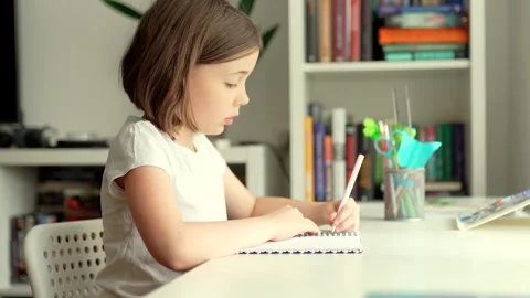 Child doing her homework at the dest at home. Education concept. Stock Footage 301976513