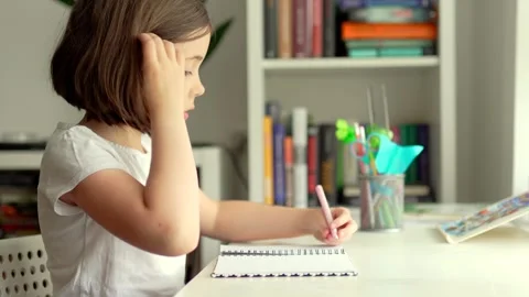 Child doing her homework at the dest at home. Education concept. Stock Footage 301976519