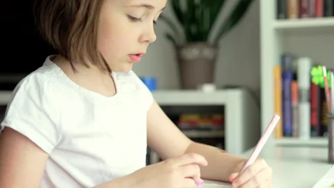 Child doing her homework at the dest at home. Education concept. Stock Footage 301976552