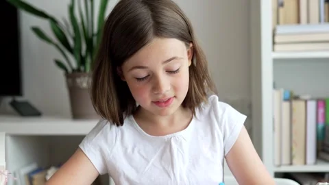 Child doing her homework at the dest at home. Education concept. Stock Footage 302287629