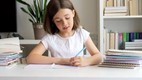 Child doing her homework at the dest at home. Education concept. Stock Footage 302287674