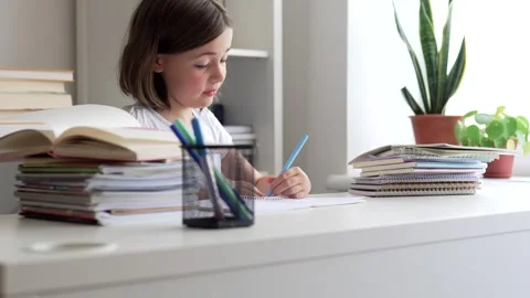 Child doing her homework at the dest at home. Education concept. Stock Footage 302287895