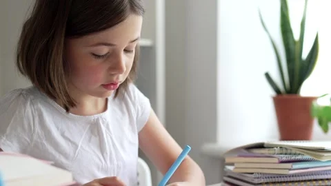 Child doing her homework at the dest at home. Education concept. Stock Footage 302288000