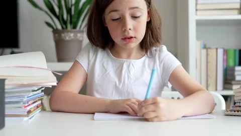 Child doing her homework at the dest at home. Education concept. Stock Footage 302288026