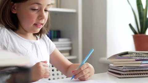Child doing her homework at the dest at home. Education concept. Stock Footage 302288106