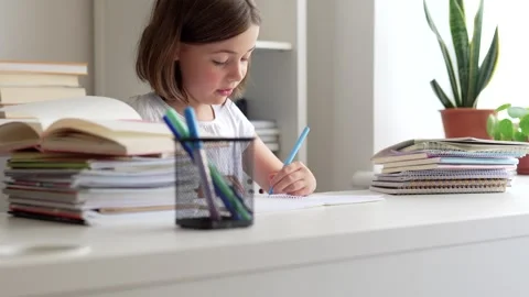 Child doing her homework at the dest at home. Education concept. Stock Footage 302288226