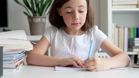 Child doing her homework at the dest at home. Education concept. Stock Footage 302288454