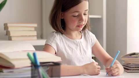 Child doing her homework at the dest at home. Education concept. Stock Footage 302288746